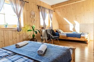 two beds in a room with wooden walls and windows at Farmerska Chata in Czarna Góra