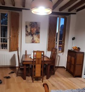 uma sala de jantar com uma mesa de madeira e cadeiras em A appartement Cozy, vue sur le port, gîte, les pieds dans l'eau em Sablé-sur-Sarthe