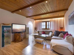 a living room with a couch and a tv at Ferienwohnung Pacher in Hopfgarten im Brixental
