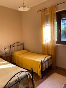 two beds in a room with a window at Casa Trachini in Palmi