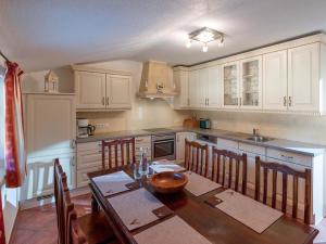 a kitchen with a wooden table and a kitchen with white cabinets at Ferienwohnung Pacher in Hopfgarten im Brixental