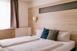 a bedroom with a bed with a wooden headboard at Hotel Vogtareuther-Hof in Vogtareuth
