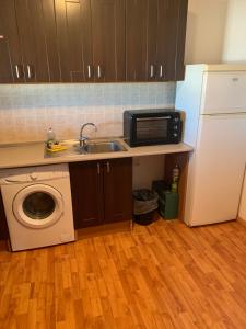 uma cozinha com um lavatório, um micro-ondas e uma máquina de lavar roupa em casa peninsula caspe 2 em Caspe