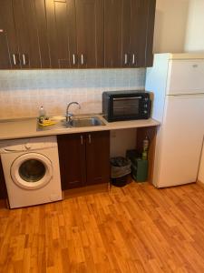 a kitchen with a sink and a microwave and a washing machine at casa peninsula caspe 2 in Caspe