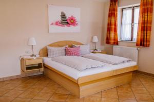 a bedroom with a wooden bed with two night stands at Hotel Vogtareuther-Hof in Vogtareuth