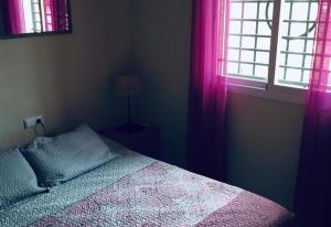 sypialnia z łóżkiem i oknem z różowymi zasłonami w obiekcie Lux Apartm Beauvivir w mieście Torre del Mar