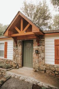 une maison avec une porte verte et un bâtiment en pierre dans l'établissement The Woodlawn Guest Cottage, à Hot Springs