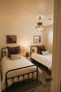 une chambre avec deux lits et un lustre dans l'établissement The Woodlawn Guest Cottage, à Hot Springs 29 autres photos
