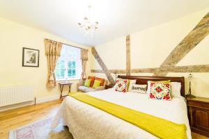a bedroom with a large bed with a yellow blanket at Molland Manor House Self catering (10 bedrooms 9 bathrooms) in Sandwich