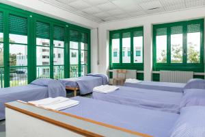 a room with blue beds and green windows at Villaggio Torre Marina in Marina di Massa +52 photos