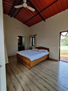 a bedroom with a bed and a ceiling fan at Roy's Nature Nest - Farm Stay near Malshej Ghats in Ghātghar