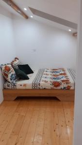 a bed in a room with a wooden floor at Appartement La Paix in Pibrac