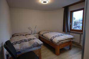 - une chambre avec 2 lits et une fenêtre dans l'établissement Touring 401, à Davos