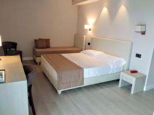 um quarto de hotel com uma cama e um sofá em Hotel Villa Barsanti em Marina di Pietrasanta