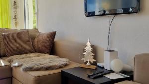 a living room with a couch and a christmas tree on a table at Valnaira (282 Dä) in Valbella
