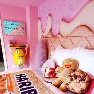 Un dormitorio con una cama de gatito de hola con una rosquilla. en Candypartment Sweets 'n Sleep en Gelsenkirchen