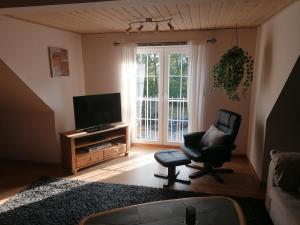 un salon avec une chaise et une télévision dans l'établissement Fewo Skjærnsøde, à Fjerritslev
