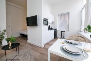 a kitchen and living room with a white table and chairs at Four Star Apartments - Keizerstraat in Scheveningen