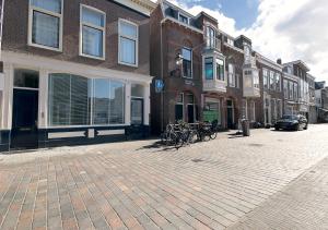 eine Backsteinstraße mit Fahrrädern, die vor Gebäuden geparkt sind in der Unterkunft Four Star Apartments - Keizerstraat in Scheveningen