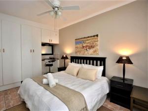 a bedroom with a large bed with a ceiling fan at Amarachi Guesthouse in Swakopmund