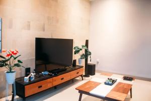 a living room with a large flat screen tv at Villa Akmali Canggu - 2 Bedrooms in Canggu