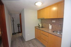 eine Küche mit Spüle und Holzschränken in der Unterkunft Casa das Laranjeiras by Gerês Casas in Carvalheira