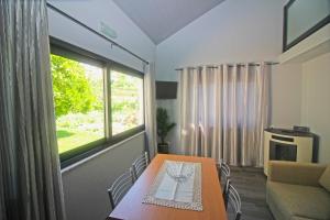 ein Esszimmer mit einem Tisch und einem Fenster in der Unterkunft Casa das Laranjeiras by Gerês Casas in Carvalheira + 18 Fotos