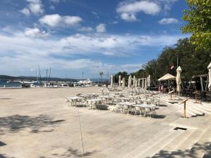 a group of tables and chairs in a parking lot at La Villa - Beach house & Rooms in Crikvenica