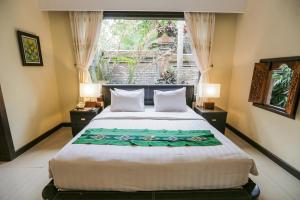 sypialnia z dużym łóżkiem i oknem w obiekcie Ubud Hotel & Cottages w mieście Malang +37 zdjęć