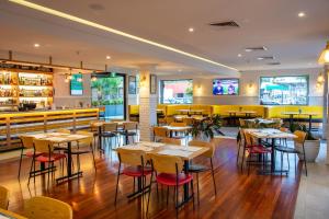 ein Restaurant mit Tischen und Stühlen und einer Bar in der Unterkunft Five Island Hotel in Cringila