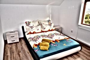 a small bedroom with a bed with flowers on it at La Miruna in Comăneşti