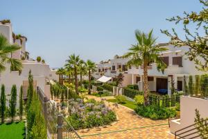 a view of the courtyard of a resort with palm trees at Higos in San Juan de los Terreros