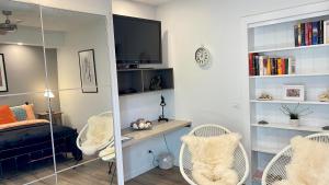 een slaapkamer met een bed, een bureau en stoelen bij River cottage in Blairgowrie