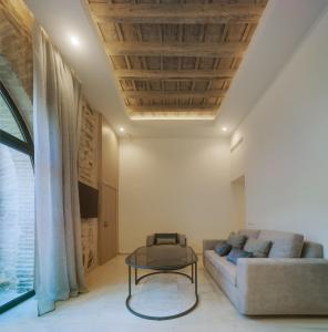 ein Wohnzimmer mit einem Sofa und einem Tisch in der Unterkunft Apartamentos Los Patios del Pañuelo in Córdoba