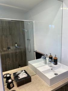 une salle de bain blanche avec lavabo et douche dans l'établissement River cottage, à Blairgowrie 11 autres photos