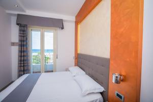 a bedroom with a large bed with a window at Hotel Gabbiano in Rimini