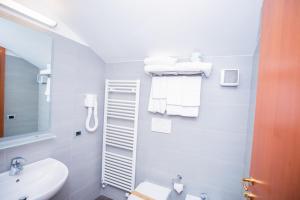 a bathroom with a sink and a toilet and towels at Hotel Gabbiano in Rimini