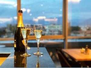 eine Flasche Champagner und zwei Gläser auf dem Tisch in der Unterkunft Granda Hotel in Tirana