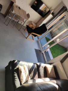 sala de estar con sofá y silla en Apartament Beti, en Oostkamp