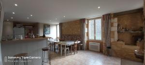 une cuisine avec une table et une salle à manger dans l'établissement CHAMBRES D'HOTES SERMUS, à Vézac