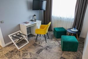 克羅斯諾的住宿－Hotel Nafta Krosno，客房设有书桌、椅子和桌子。