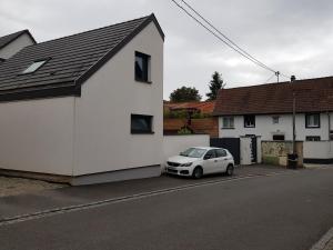 um carro branco estacionado ao lado de uma casa branca em Superbe appartement type T1 proche Strasbourg em Truchtersheim