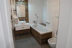 a bathroom with a tub and a sink and a toilet at Hotel Nafta Krosno in Krosno