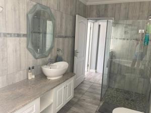 a bathroom with a sink and a shower at Golfers View @ Kingswood Golf Estate in George