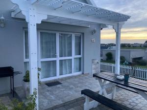 a white pergola on a patio with a bench at Golfers View @ Kingswood Golf Estate in George +6 photos