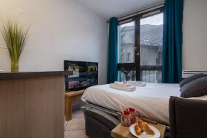 une chambre d'hôtel avec un lit et une table avec une assiette de nourriture dans l'établissement Chamonix Sud - Balme 111 - Happy Rentals, à Chamonix-Mont-Blanc