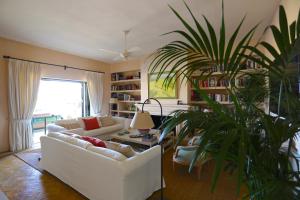 a living room with a white couch and a plant at Las Ranas CASASOLA BEACH & GOLF VILLA in Estepona