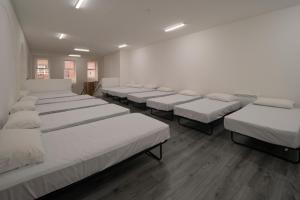 a row of beds in a room with white mattresses at Harbourside Hostel Bristol in Bristol