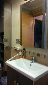 Un baño con un lavabo blanco y un espejo. en CASA LOS BLOQUES, en Zamora