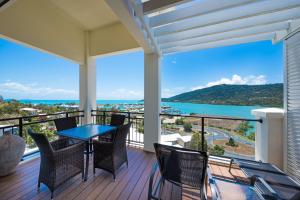 un balcone con tavolo e sedie e vista sull'oceano di The Sebel Whitsundays ad Airlie Beach